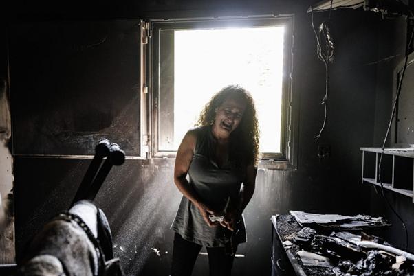 Kibbutz Nir Oz resident Hadas Kalderon, whose children have been taken hostage, and her mother and niece killed, breaks down in tears while looking through the burnt out home of her late mother Rina Sutzkever on October 30, 2023 in Kibbutz Nir Oz, Israel. Photo by Dan Kitwood/Getty Images