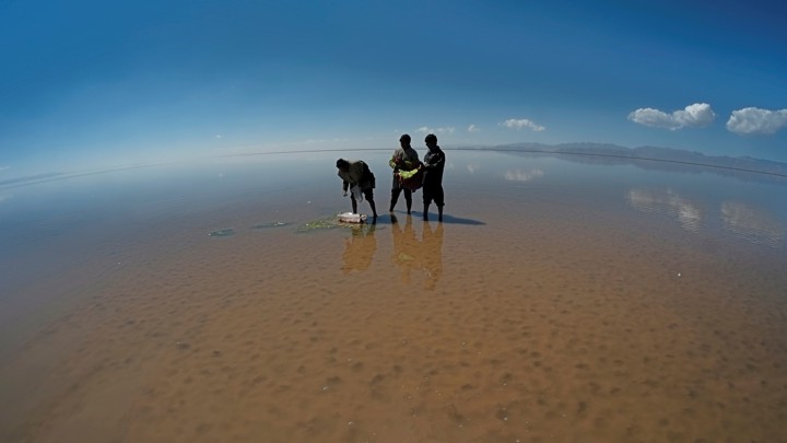 Men perform a ceremony on the drought-stricken bed of Poopo, a lake in Bolivia