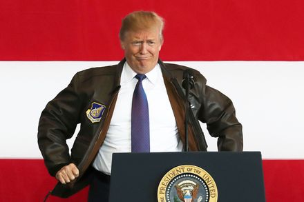 U.S. President Donald Trump puts on a military jacket as he meets the US troops at the U.S. Yokota Air Base, on the outskirts of Tokyo, Nov. 5, 2017.