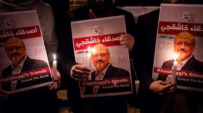 People hold posters picturing Saudi journalist Jamal Khashoggi and a lighted candle during a gathering outside the Saudi Arabian consulate in Istanbul, on October 25, 2018. (Photo by AFP)