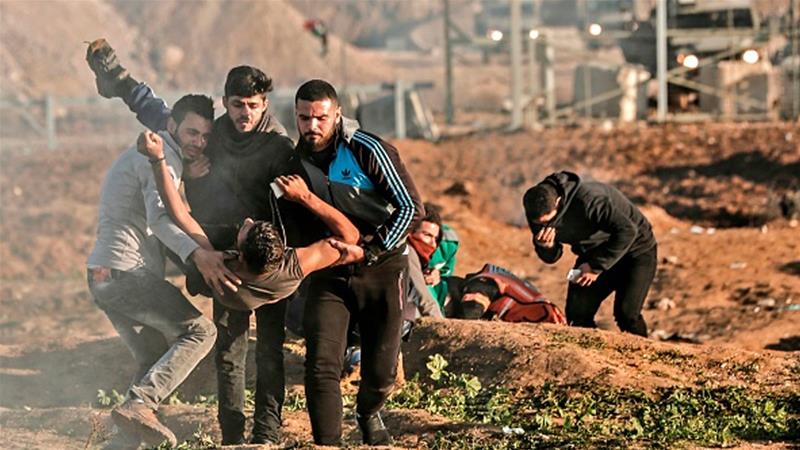In this file photo, Palestinians carry away a protester, injured by Israeli forces along the Gaza Strip's perimeter fence [File: Mahmud Hams/AFP]